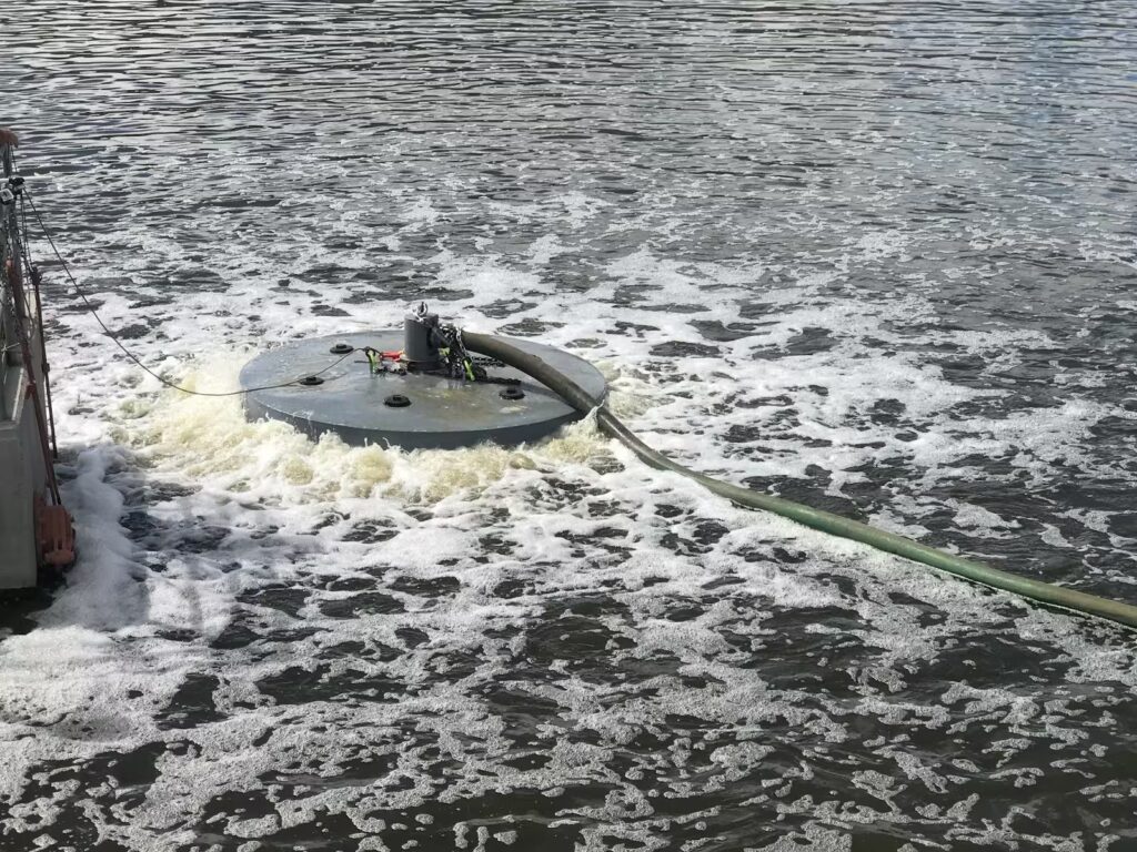 Surface aerators in action on a wastewater lagoon, showing the high-maintenance side of sludge reduction compared to Titus WWS’ modern floating aeration.