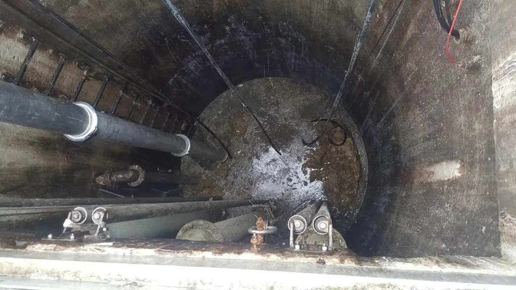 Interior view of a wastewater pump station showing grease matting, a common maintenance issue that leads to odors as dissolved sulfides convert to H2S gas, creating safety, odor, and corrosion concerns.
