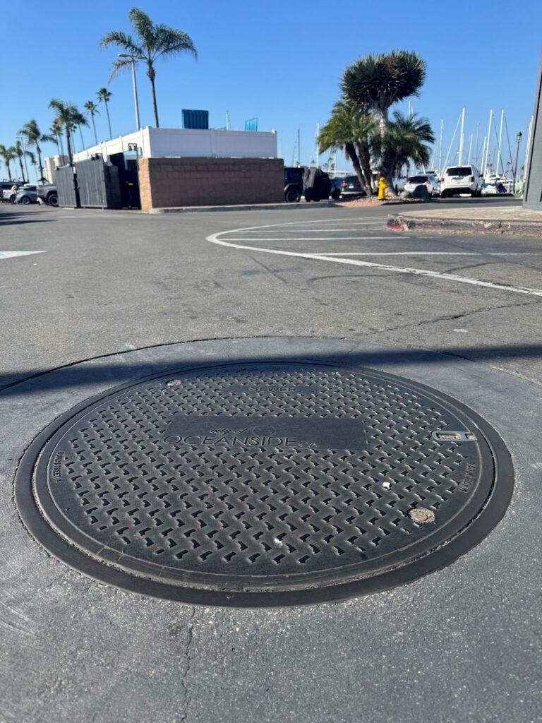 Installed composite manhole cover in an Oceanside, California municipal roadway designed to reduce manhole I&I. 