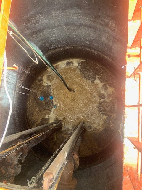 Titus Twister aerator running inside a wastewater lift station, breaking up a greasy FOG layer on the surface.