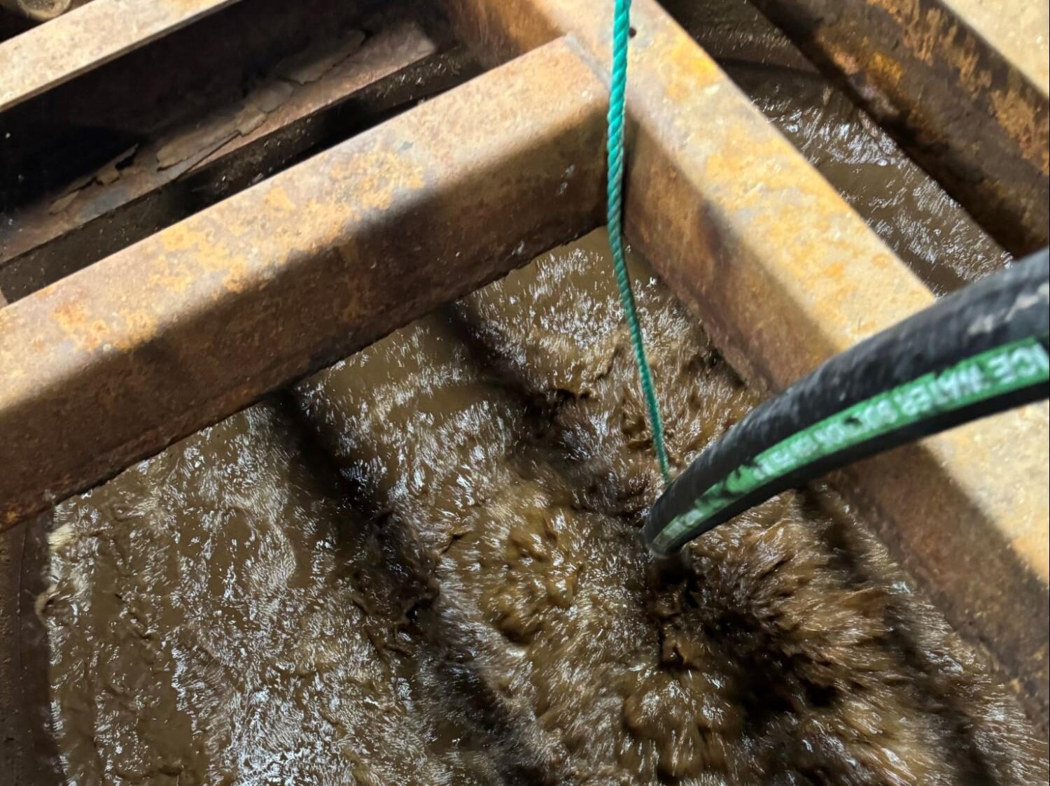 Close-up of chicken processing wastewater being actively mixed and aerated, with churning surface turbulence and heavy organic load in a treatment basin.