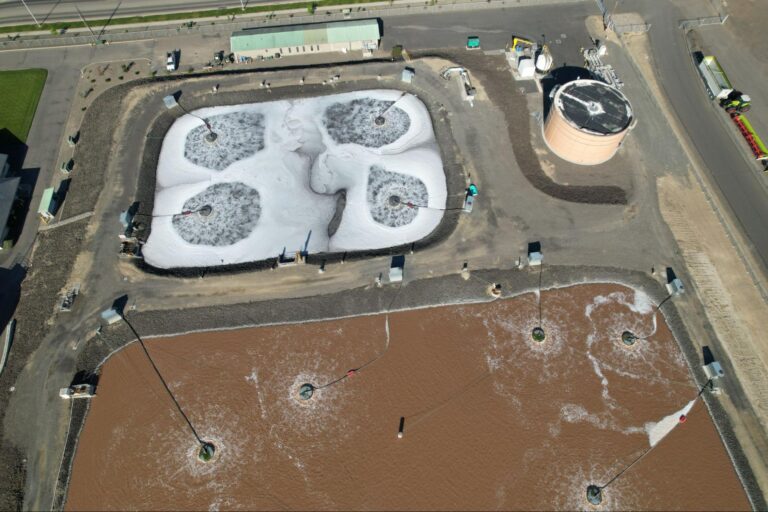 Aerial view of industrial wastewater treatment lagoons with multiple surface aerators in operation, showing the varied waste streams behind industrial wastewater treatment challenges.